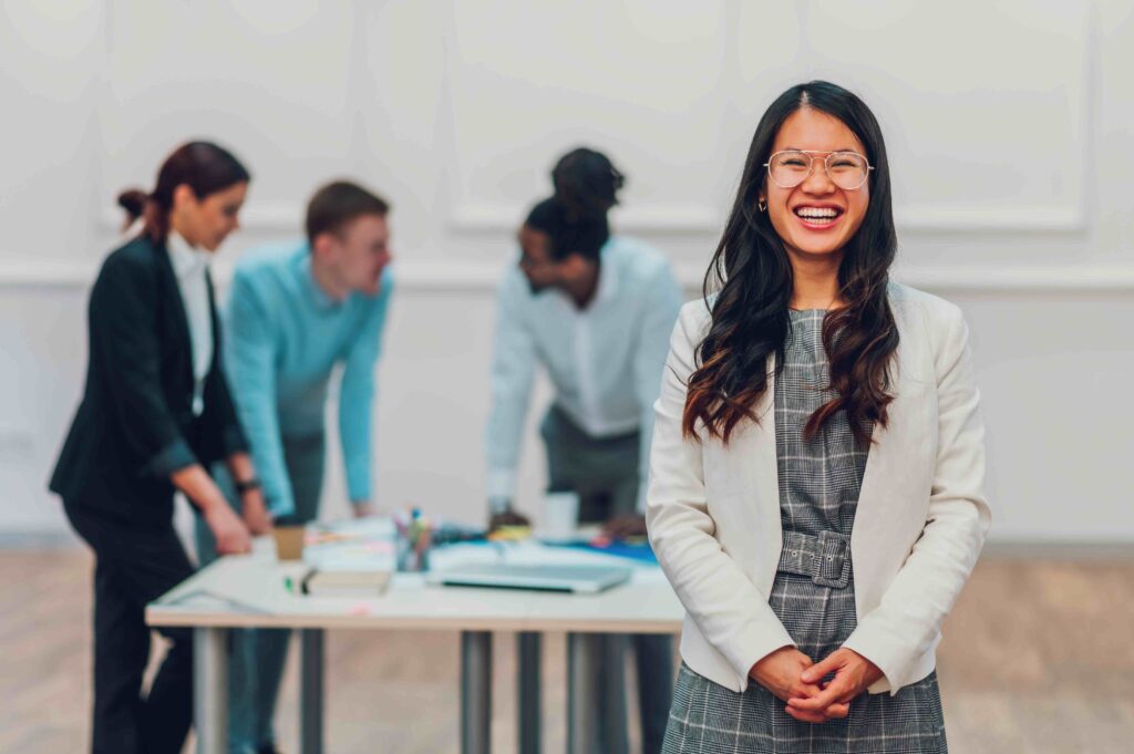 Confident professional speaking to a group during a team meeting, representing assertive communication and leadership skills.