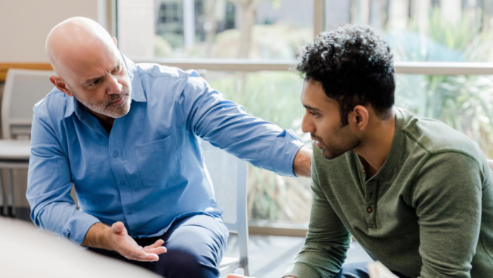 Manager demonstrating emotional intelligence by coaching and actively listening to an employee during a one-on-one workplace discussion.