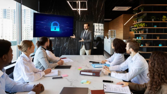 Corporate cyber security training session with employees attending a data protection and cyber awareness presentation in a modern office meeting room.