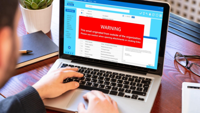 Laptop displaying a phishing email warning message advising users to be cautious when opening attachments or clicking links, highlighting email security awareness and cyber security training.