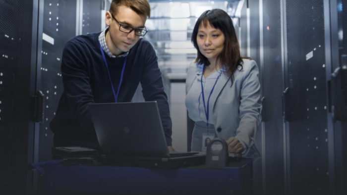 Data center professionals working on server infrastructure with a laptop
