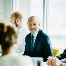Business leader demonstrating emotional intelligence by actively engaging with team members during a collaborative workplace meeting.
