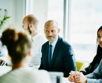 Business leader demonstrating emotional intelligence by actively engaging with team members during a collaborative workplace meeting.