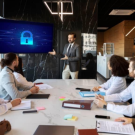 Corporate cyber security training session with employees attending a data protection and cyber awareness presentation in a modern office meeting room.