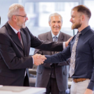 Professional employee receiving recognition and promotion from a senior manager in a corporate workplace
